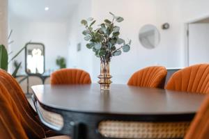 卢森堡Modern 2BR in Central Luxembourg Near Old Town的一张桌子上放着一个花瓶，还有橙色的椅子 更多29张照片