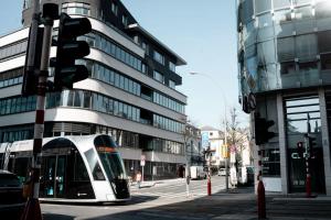 a tram on a city street in front of a building at Modern 2BR in Central Luxembourg Near Old Town in Luxembourg