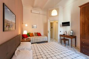 Habitación con 2 camas, escritorio y TV. en Redseven Rome Apartment en Roma