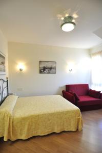 1 dormitorio con 1 cama y 1 sofá rojo en Hotel Apartamentos Aralso Sotillo en La Lastrilla