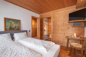 1 dormitorio con 1 cama y TV de pantalla plana en Neuhaus-Hof by FeWo-PLAN REIT100, en Reith im Alpbachtal