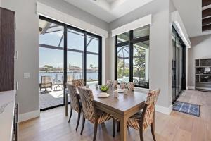 een eetkamer met een tafel en stoelen met uitzicht op het water bij Luxurious home with pool/spa and huge water view in Marco Island