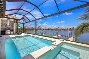 een binnenzwembad met uitzicht op het water bij Luxurious home with pool/spa and huge water view in Marco Island