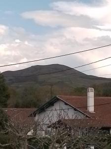 a house with a mountain in the background at Studio entre montagne et mer in Cambo-les-Bains