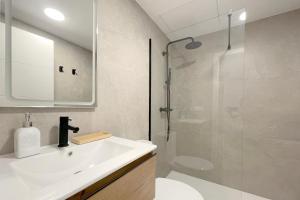 a bathroom with a white sink and a shower at Apartamento Boutique en el corazón de Ronda in Ronda
