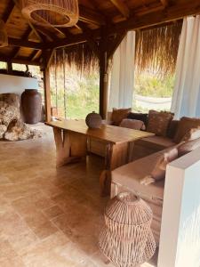 uma sala de estar com uma mesa de madeira e um sofá em Le Loys Martinique em Sainte-Anne