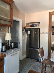 a kitchen with a black refrigerator and a table at Luminescent in Buffalo