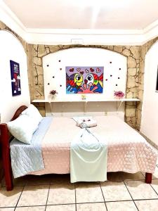 1 dormitorio con 1 cama y una pintura en la pared en Pousada Brasil Natal, en Natal