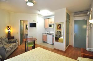 a living room and kitchen with a couch and a table at Hotel Apartamentos Aralso Sotillo in La Lastrilla