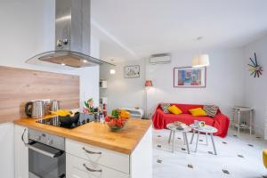 una cucina e un soggiorno con divano rosso di Appartement Picasso - Vieil Antibes - Happy Rentals a Antibes