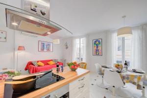 una cucina e un soggiorno con divano rosso di Appartement Picasso - Vieil Antibes - Happy Rentals a Antibes