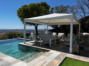 una sombrilla blanca sentada junto a una piscina en Sitges Spaces Sea View Villa- 6 Bedrooms, 5 bathrooms, 2 private pools, Near center, en Sitges