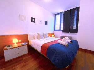 un dormitorio con una cama con dos animales de peluche en Tropicalidays Apartamento Zona Centros Comerciales, en Santa Cruz de Tenerife