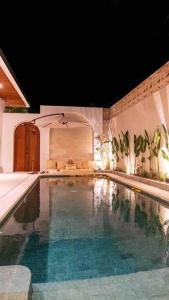 a large swimming pool in a room with at Budget villa #evara villa in Tumbak Bayuh