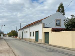 un bâtiment blanc sur le côté d'une rue dans l'établissement Aveiro Maias Village - CASA DA ROSA, 