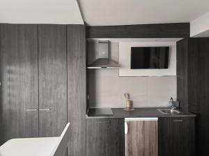 a kitchen with wooden cabinets and a sink at Estudio Central in Estepona +4 photos