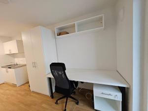 einen weißen Schreibtisch und einen Stuhl in einem Zimmer in der Unterkunft State of the Art Apartment in the City Center Nürnberg in Nürnberg