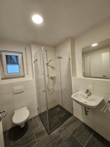 a bathroom with a shower and a toilet and a sink at State of the Art Apartment in the City Center Nürnberg in Nuremberg