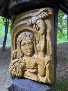 a wooden carving of a woman holding a bird at Stripeikių Bitė in Varniškės I