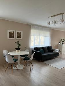 sala de estar con sofá, mesa y sillas en Palova_brown, en Vilgāle