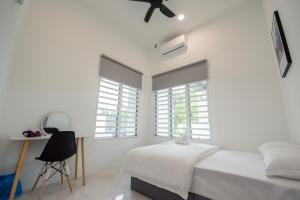 um quarto com paredes brancas e uma cama com uma ventoinha em De Luma Alma 9 bedroom with 8 bathroom em Bukit Mertajam