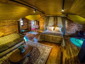 a bedroom with a bed and a couch in a room at Pousada Rugero in Nova Pádua