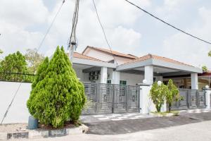 uma casa com uma árvore em frente em De Luma Alma 9 bedroom with 8 bathroom em Bukit Mertajam