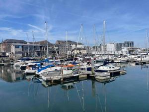 a group of boats docked in a harbor with buildings at Central City Centre 3 bedroom home Private Parking in Plymouth