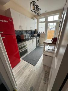a kitchen with a red refrigerator and a red door at Central City Centre 3 bedroom home Private Parking in Plymouth