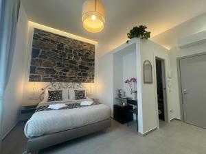 a bedroom with a bed and a brick wall at Lina suites & rooms in La Spezia