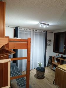 a small room with a bunk bed and a television at Studio au pied des pistes avec vue sur la montagne in Mieussy
