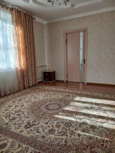 una habitación vacía con una alfombra grande en el suelo en A cosy House with a wonderful Garden en Khorog