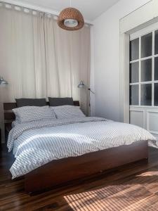 a white bedroom with a large bed and a window at Stylowy Park Apartment Wawrzyniaka in Wrocław