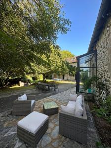 eine Terrasse mit 2 Sofas, einem Tisch und einem Tisch in der Unterkunft Gîte en Corrèze 12 pers, Piscine chauffée et Salle de jeux in Chamboulive