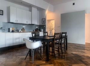 a kitchen with a black table and chairs at Stylowy Park Apartment Wawrzyniaka in Wrocław