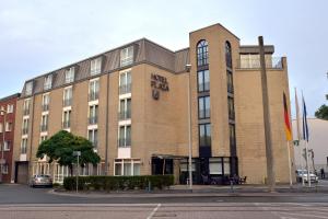 een groot bakstenen gebouw in een stadsstraat bij Hotel Plaza in Duisburg