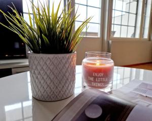 une bougie et un vase sur une table avec une plante dans l'établissement Apartment Kehtola, Tahkovuori, à Kuopio