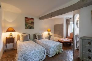 une chambre avec deux lits et une chaise dans l'établissement Le MAS des BANYONS, à Mougins 30 autres photos