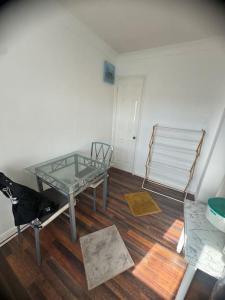 a room with a glass table and a chair at Spacious,warm room in London in Mitcham