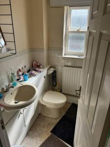 a small bathroom with a toilet and a sink at Spacious,warm room in London in Mitcham