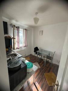 a living room with a sink and a table at Spacious,warm room in London in Mitcham