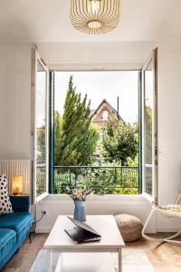 - un salon avec un canapé bleu et une grande fenêtre dans l'établissement Lovely House - Near Paris and Orly Airport, à Juvisy-sur-Orge