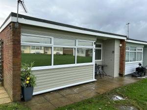 a house with a large window on the side of it at 44 Sundowner Hemsby in Great Yarmouth +6 photos