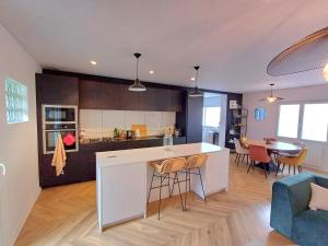 a kitchen and living room with a counter and chairs at Ranndi Terras - Yourhosthelper conciergerie in Lanester