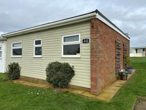 a house with a brick wall and windows at 44 Sundowner Hemsby in Great Yarmouth