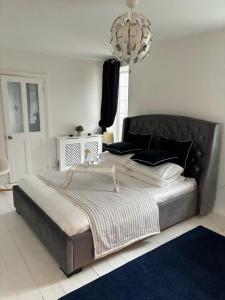 a large bed in a bedroom with a chandelier at Jurassic Hideaway in Budleigh Salterton