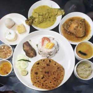 a table with plates of food on a table at Royal Guest House in Kolkata