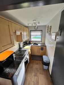 a small kitchen with a stove and a sink at 44 Sundowner Hemsby in Great Yarmouth