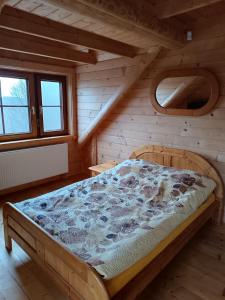 ein Schlafzimmer mit einem Bett in einem Blockhaus in der Unterkunft Wczasowisko Rudawski Zakątek in Wieściszowice