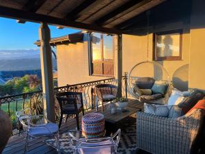 a patio with chairs and a table on a balcony at Pezula Magic Escape - Guest House - No Loadshedding in Knysna